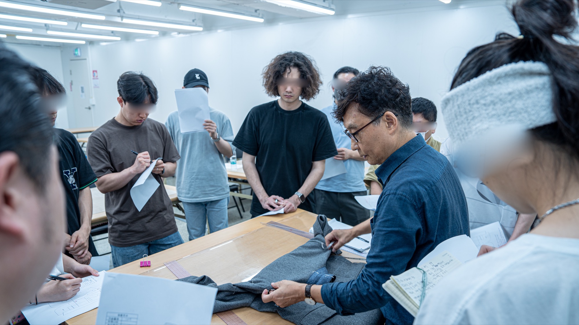 수강생 앞에서 재킷의 구조와 실루엣을 설명하는 장면